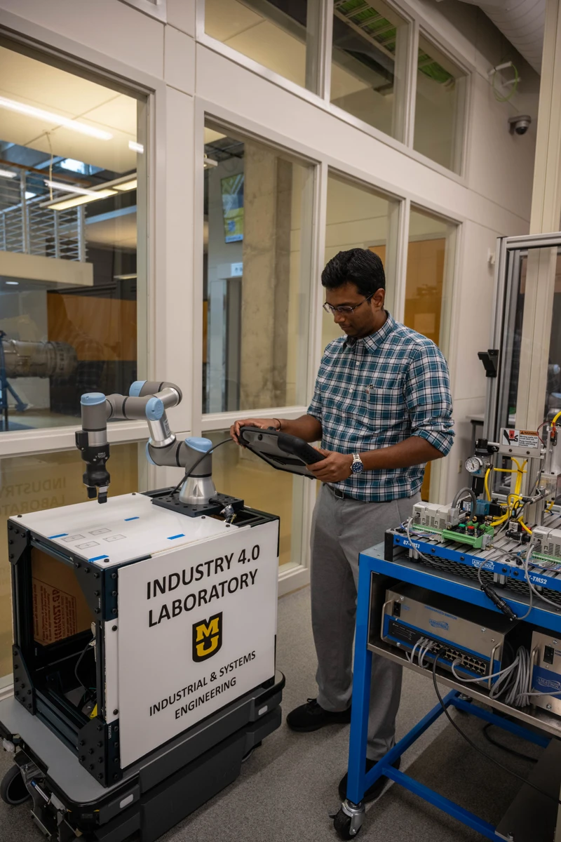 Sharan Srinivas operating a robot controller in the Industry 4.0 laboratory