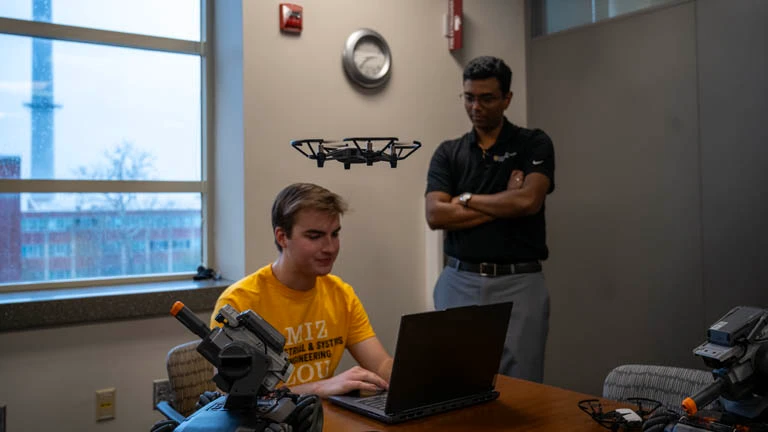 A student operating a drone with Sharan Srinivas in a teaching laboratory