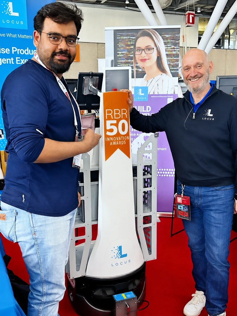 PhD student Arghadeep Mitra with an industry professional beside a Locus autonomous mobile robot.